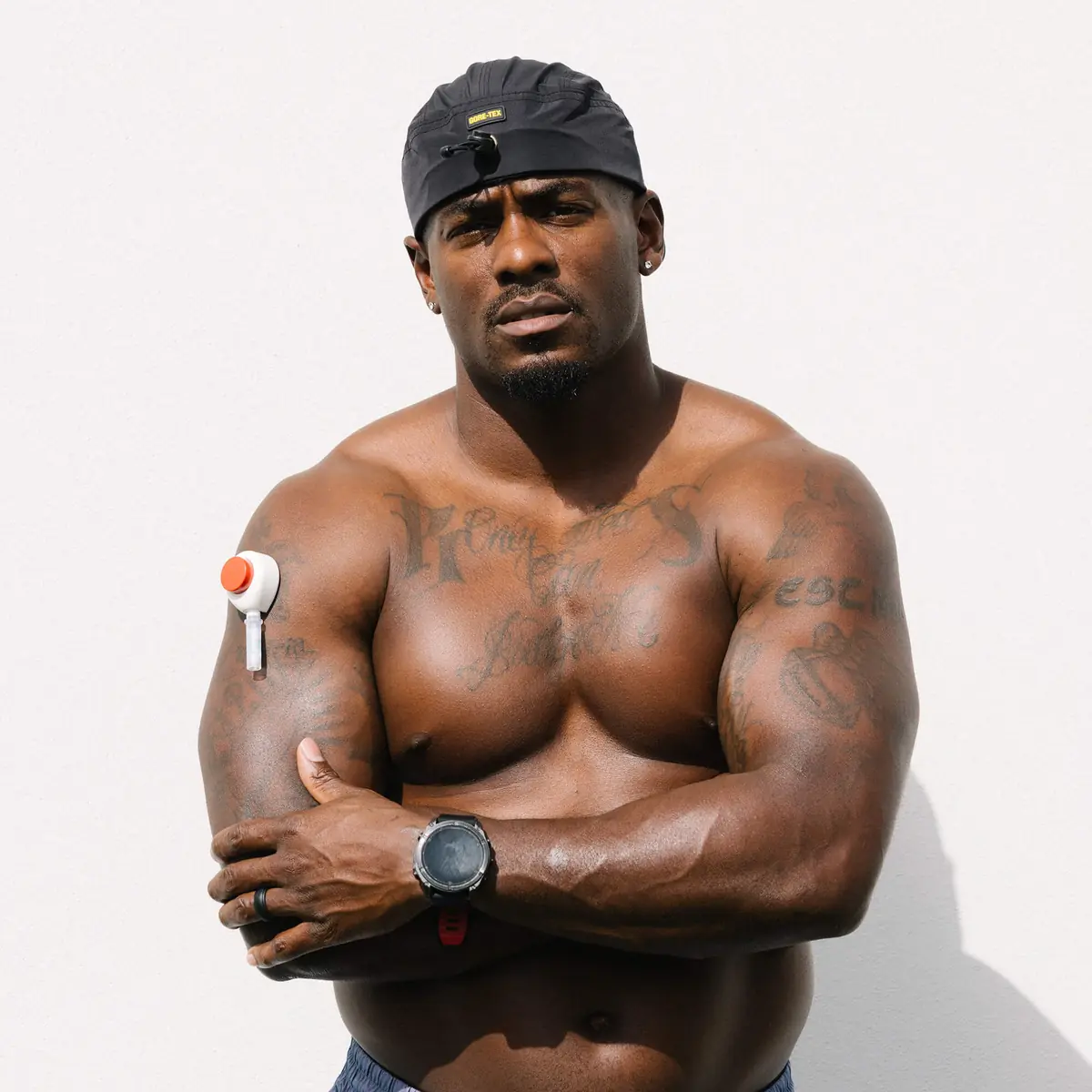 Rashaad outdoors with arms crossed wearing a Rythm Health sensor on his upper arm.
