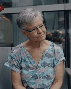 Older woman sitting outdoors, representing patient demographics and health monitoring.