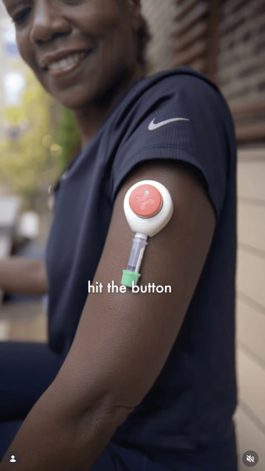 Person wearing a Rythm device on their upper arm with text “hit the button.”