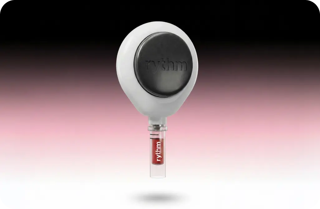 Rythm Health peptide delivery device with vial attachment, floating against a soft pink-to-black gradient background.