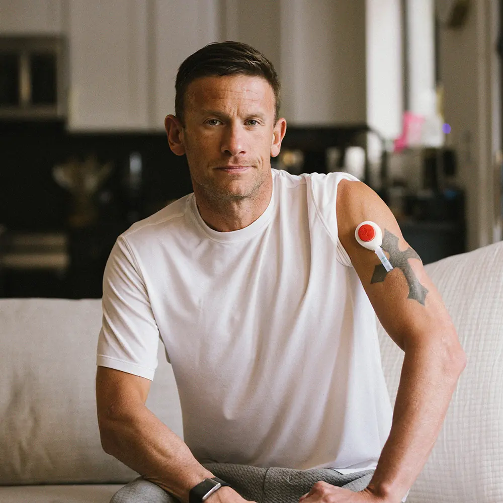 Lionel seated indoors wearing a Rythm Health sensor on his upper arm.