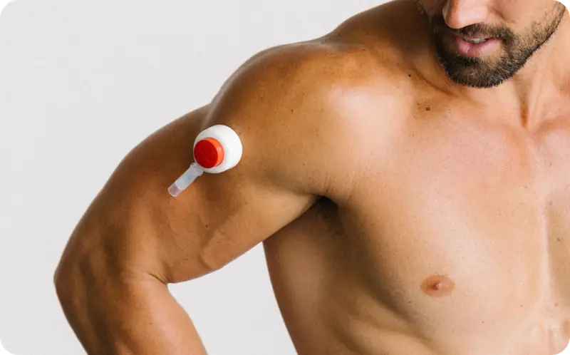 Close-up of a Rythm Health peptide device applied to a man's upper arm, showing the white and red applicator.