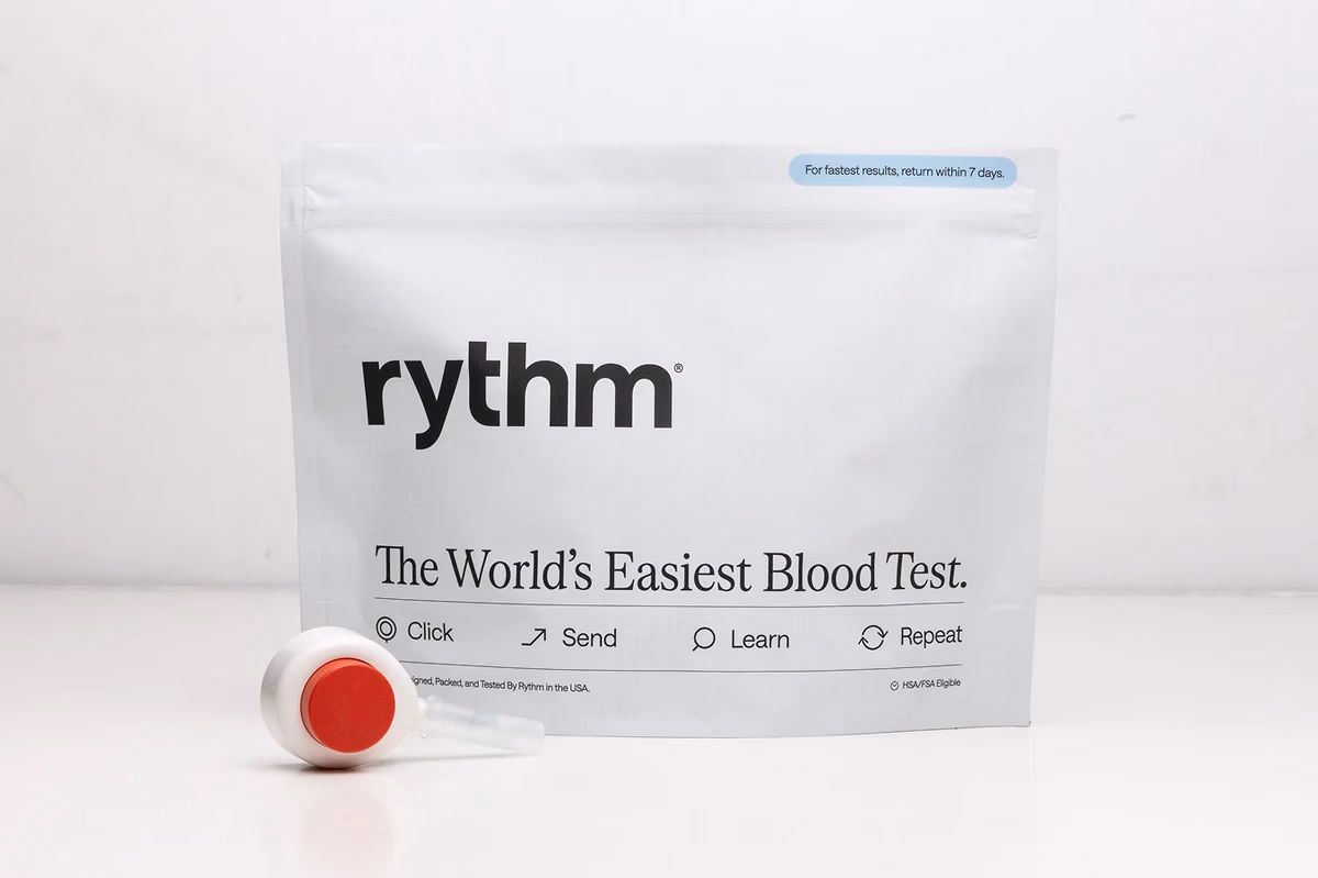 Rythm at-home blood test kit package placed on a wooden surface, showing branding and product details.